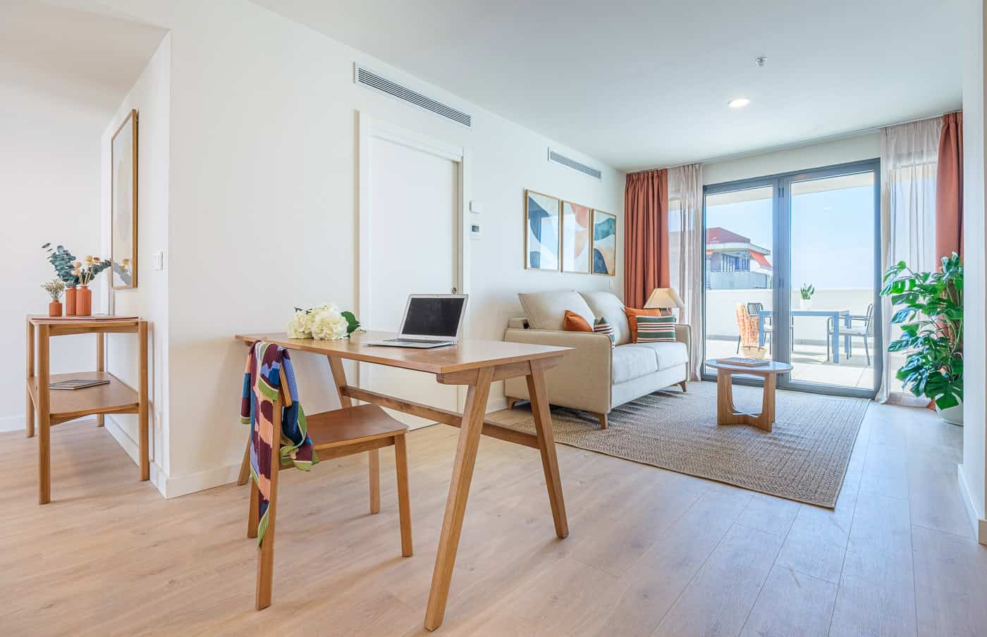 Interior de un apartamento moderno con balcón y vista al mar.