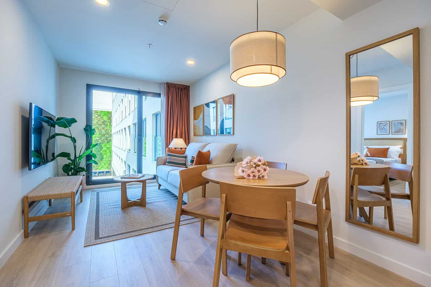 Sala moderna y luminosa con balcón y decoración minimalista en tonos neutros.