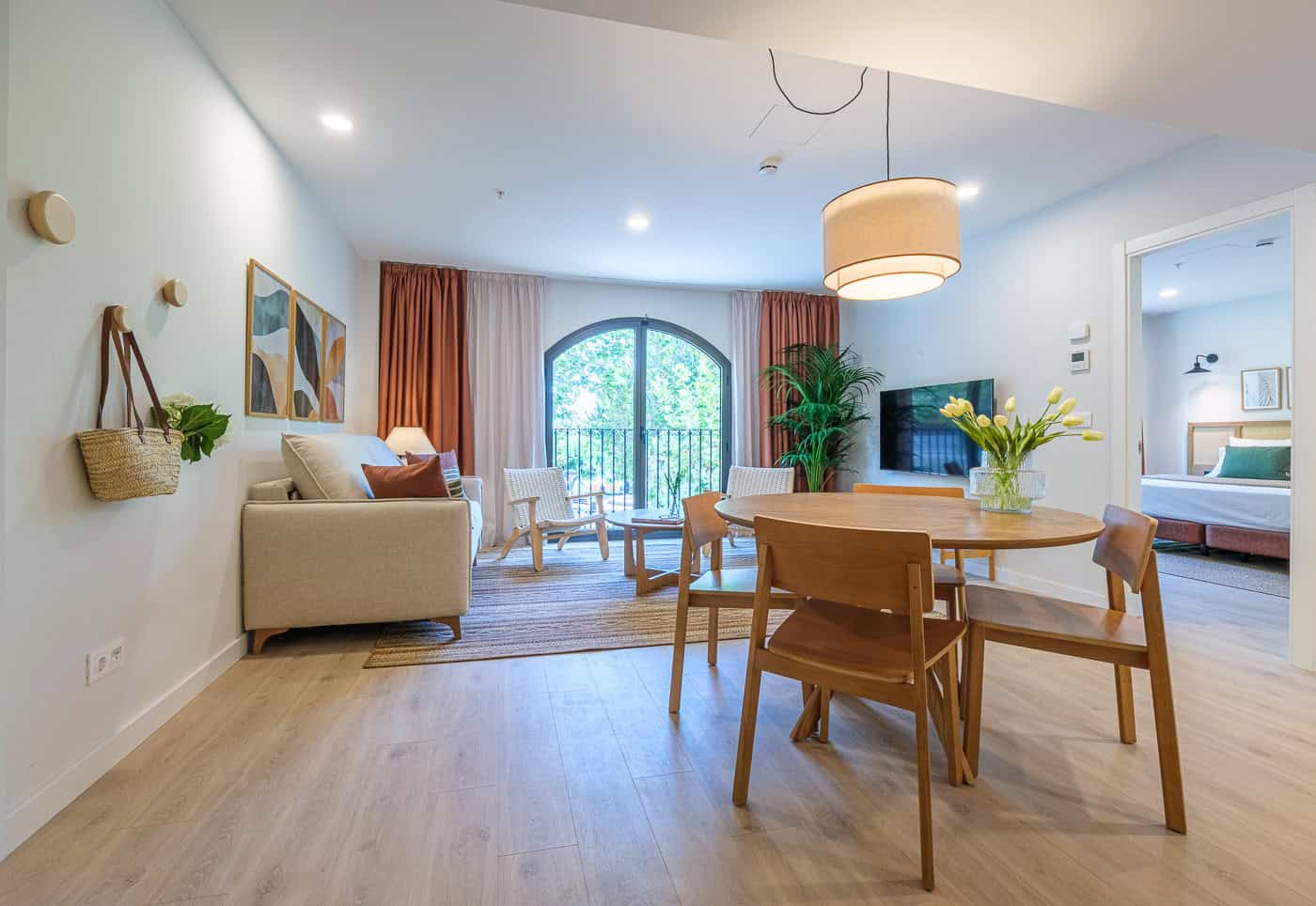 Sala de estar moderna y luminosa con balcón y decoración minimalista.